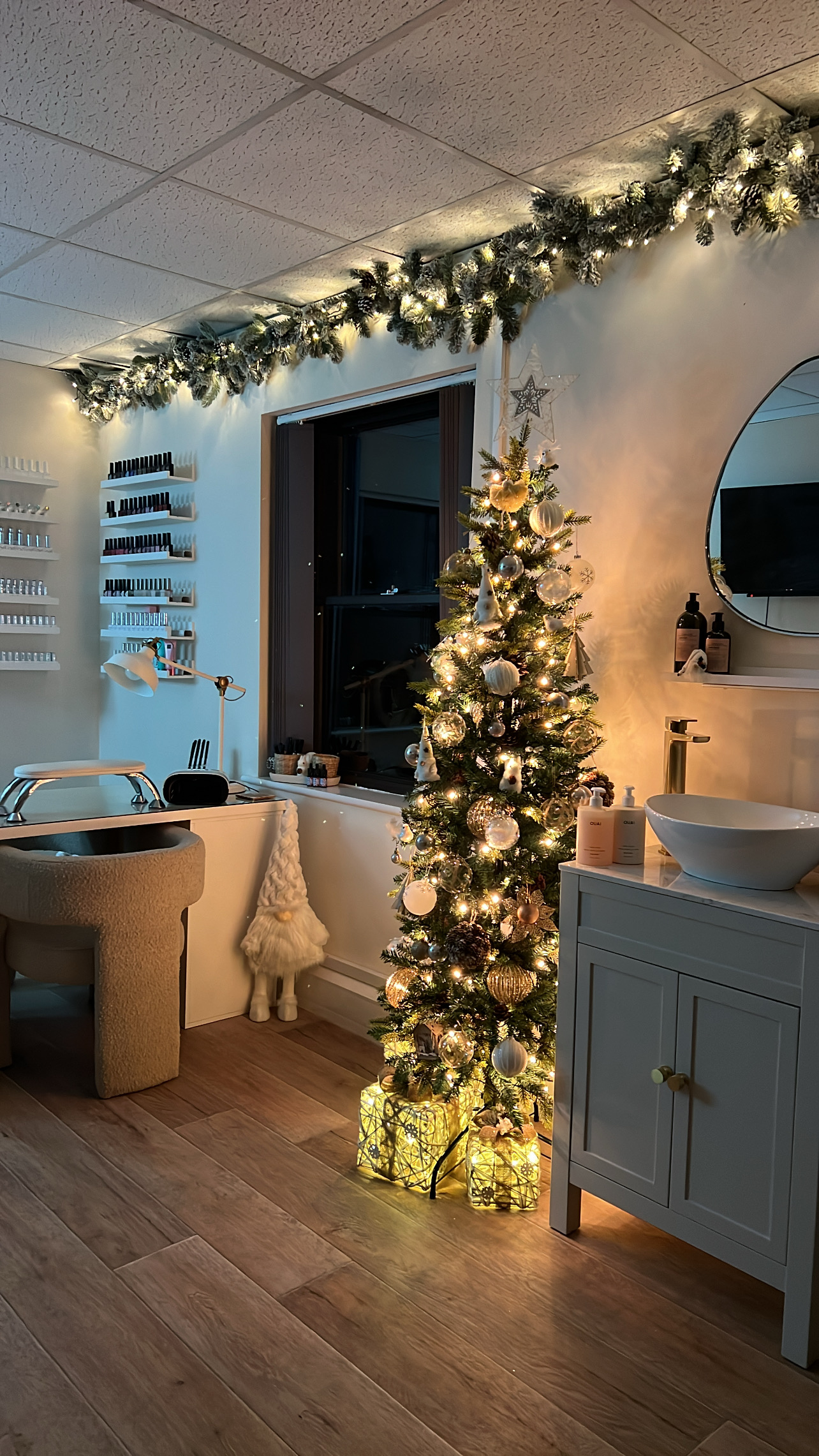 The studio lit up for Christmas, with a decorated tree beside the pedicure basin